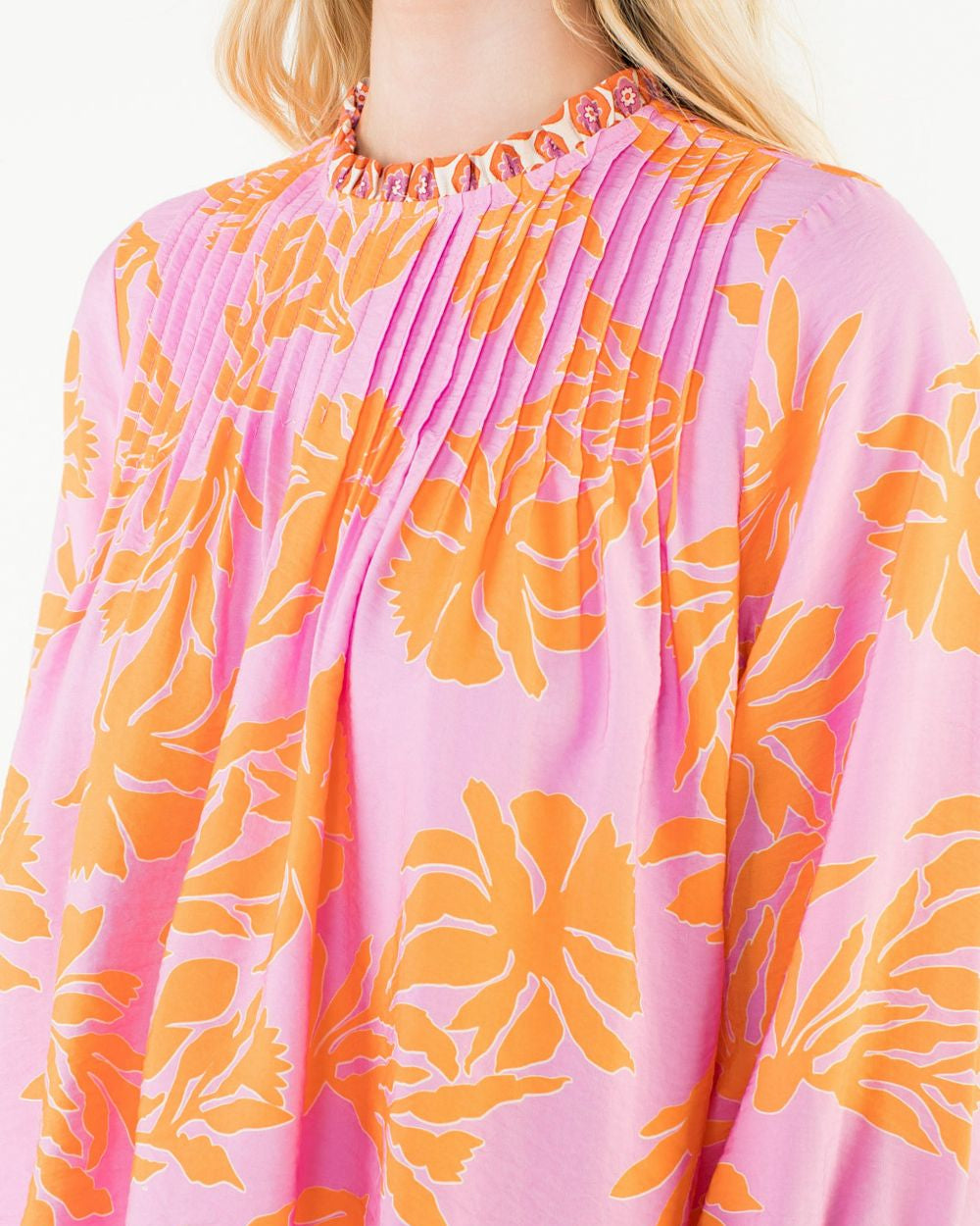 Close-up of a pink blouse with orange floral patterns