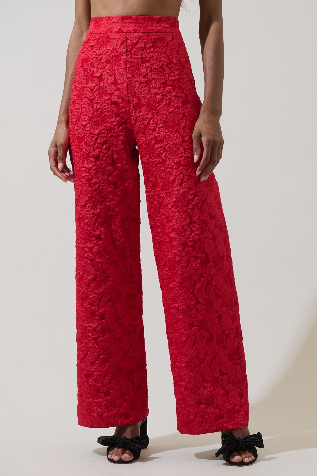 Red textured pants worn by a person on a plain background