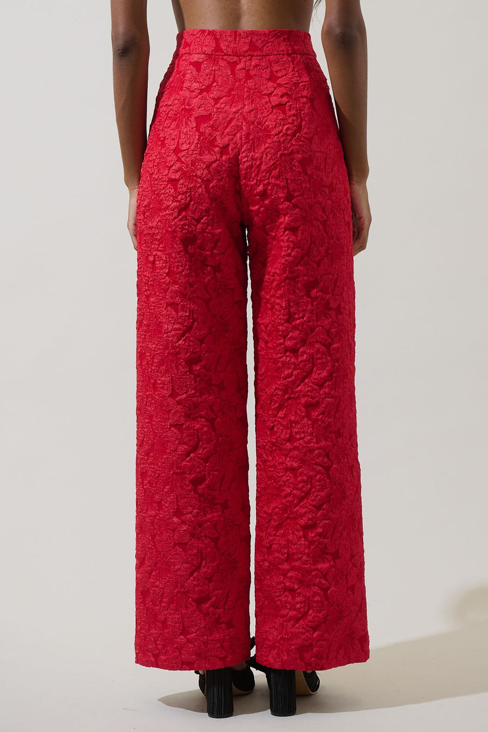 Red textured pants worn by a person on a plain background