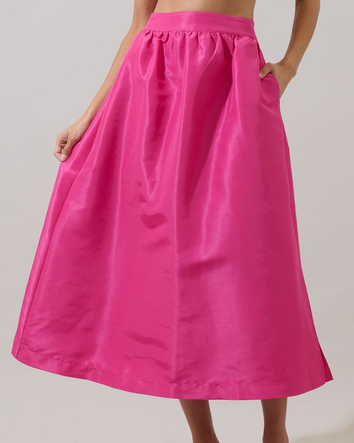 Person wearing a bright pink skirt on a plain background
