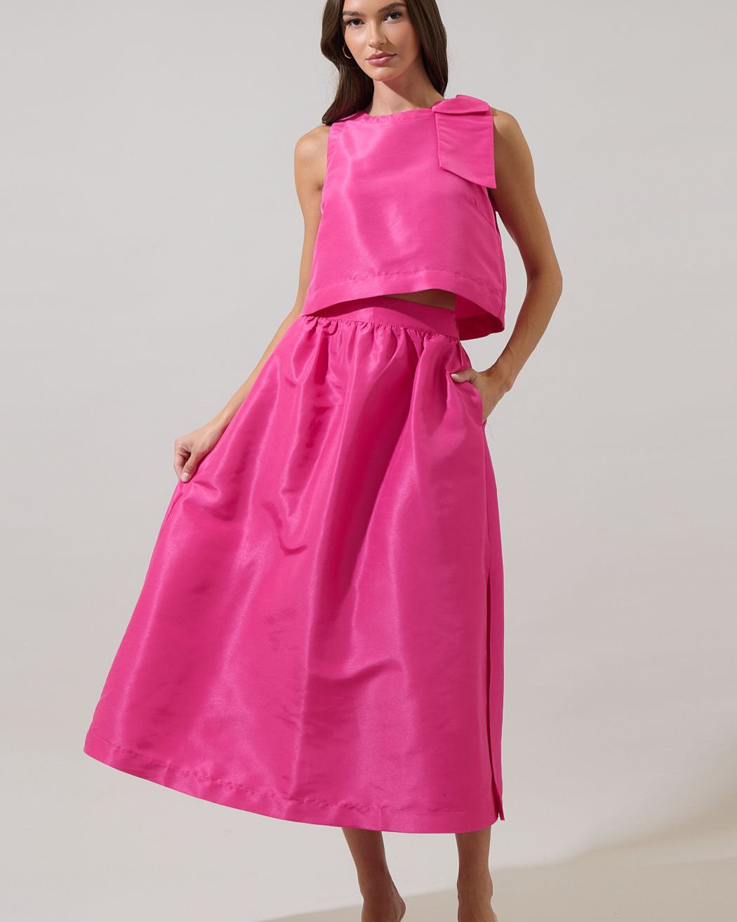 Woman wearing a bright pink dress against a plain background