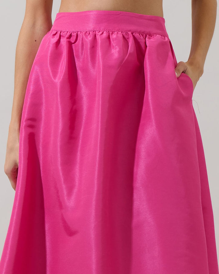 Close-up of a bright pink skirt with a plain background