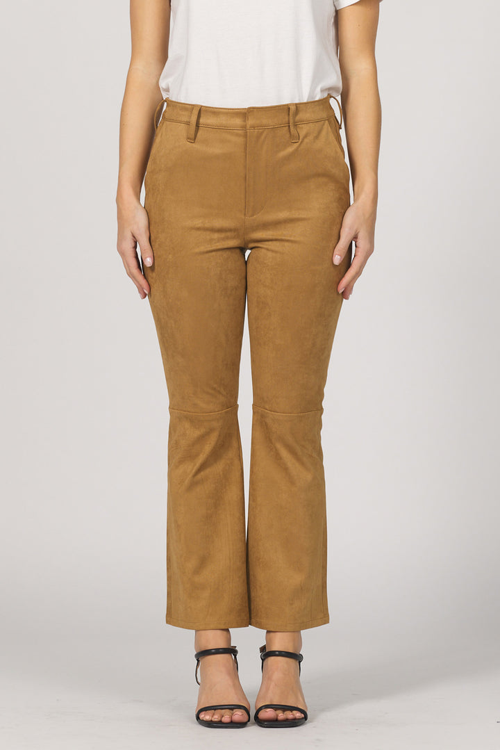 A pair of mid-rise butterscotch-colored suede pants with a wide hem and cropped length, paired with a white top and black strappy sandals.