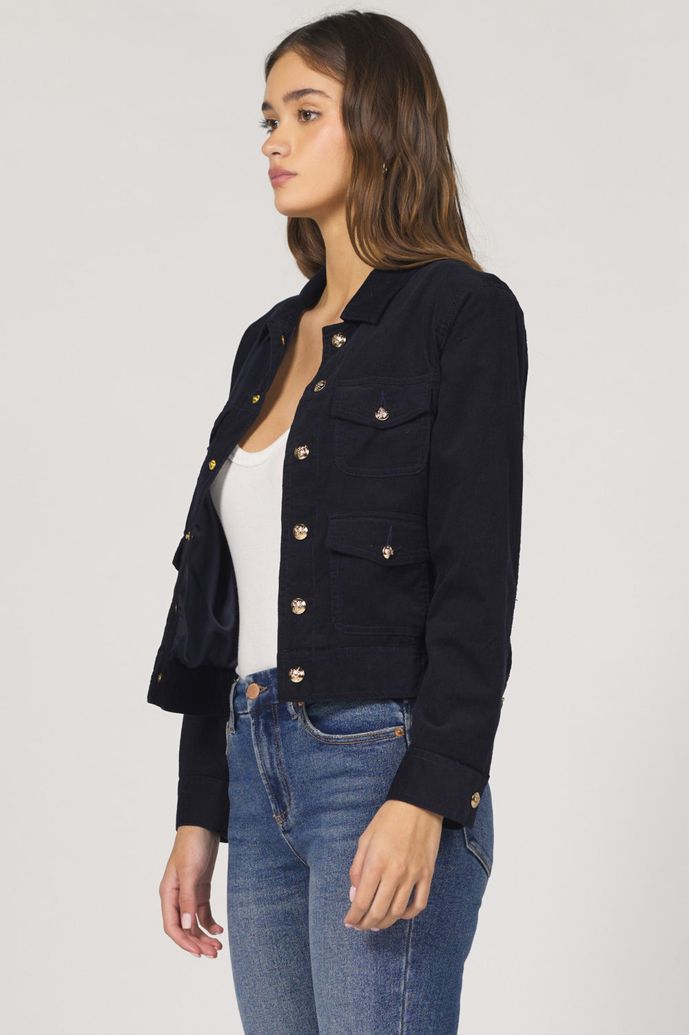 Woman wearing a black jacket and blue jeans on a white background