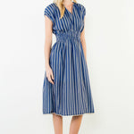 Woman wearing a blue and white striped dress on a white background