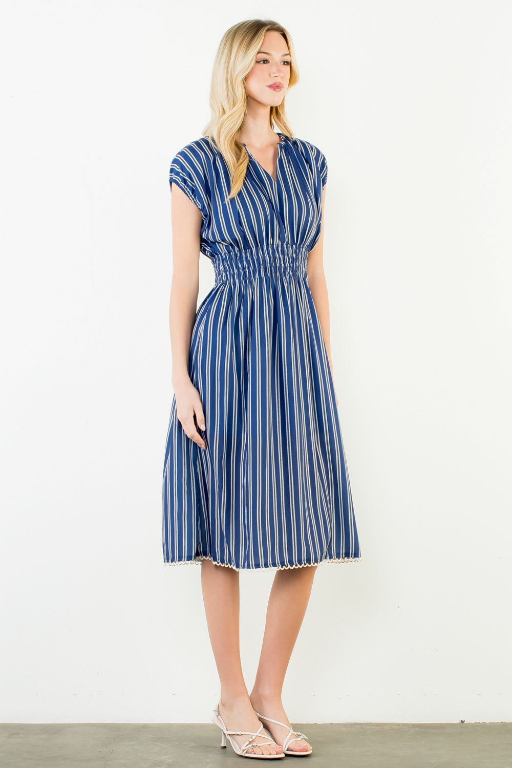 Woman wearing a blue and white striped dress on a white background
