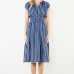 Woman wearing a blue and white striped dress against a white background