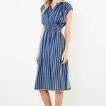 Woman wearing a blue and white striped dress against a white background