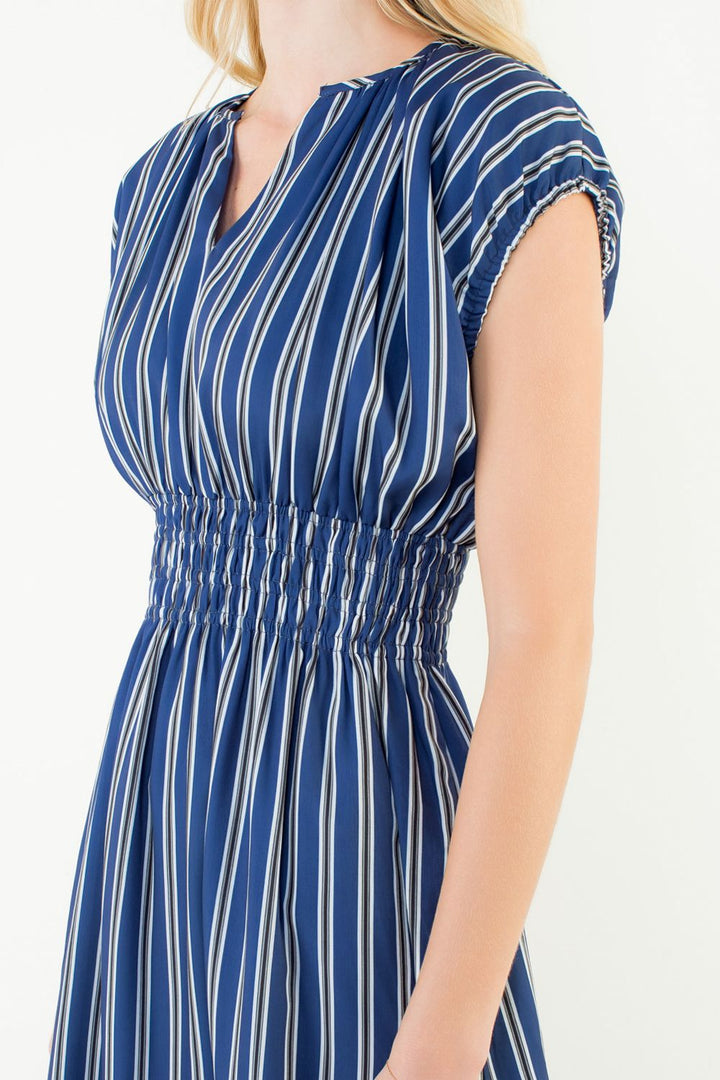 Woman wearing a blue and white striped dress on a white background