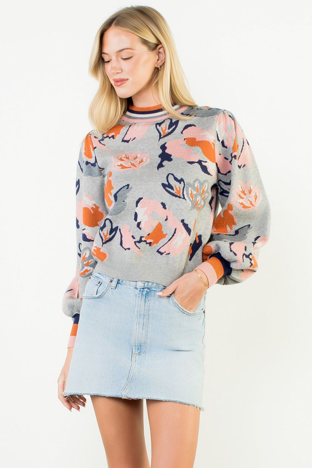 Woman wearing a colorful sweater with floral patterns on a white background