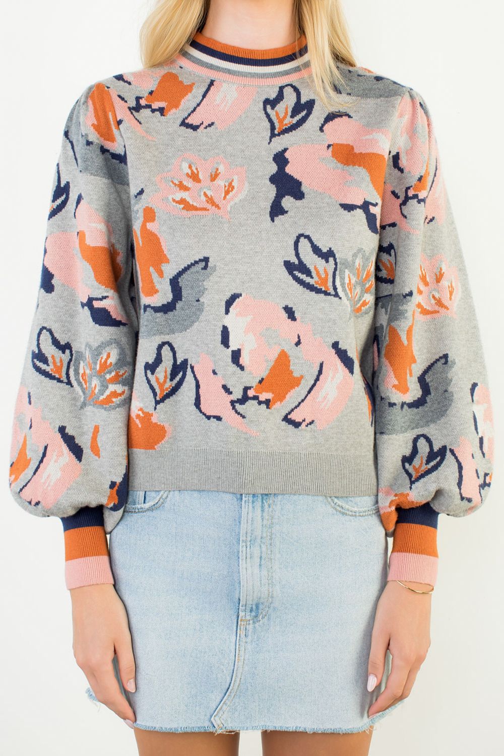 Person wearing a floral-patterned sweater with a plain background