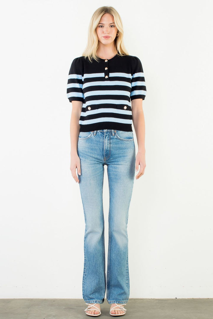 Woman wearing a black and white striped shirt and light blue jeans on a white background