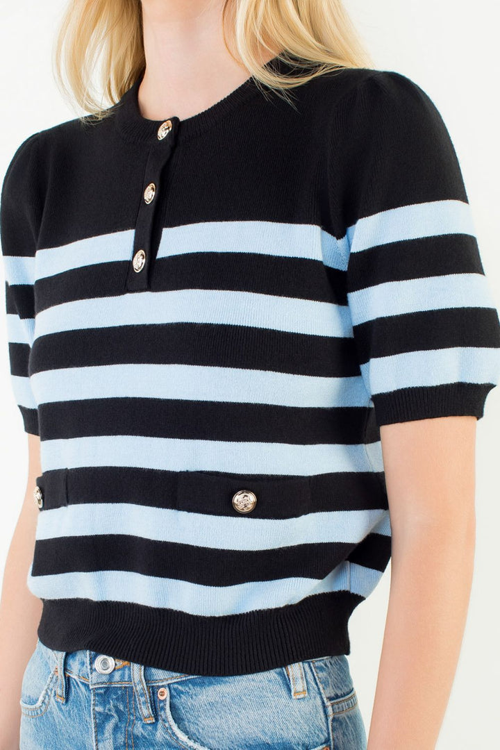 Black and light blue striped sweater worn by a person on a white background