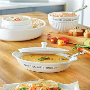3-piece set. Ceramic au gratin baker features debossed “One hot little number” sentiment, fluted details, side handles, removable lid and arrives tied with vintage-style stamped silverplated spoon.  Ceramic is oven safe to 350 degrees. Size: baker with lid 3″ x 9″ x 5″, spoon is 5 1/2″